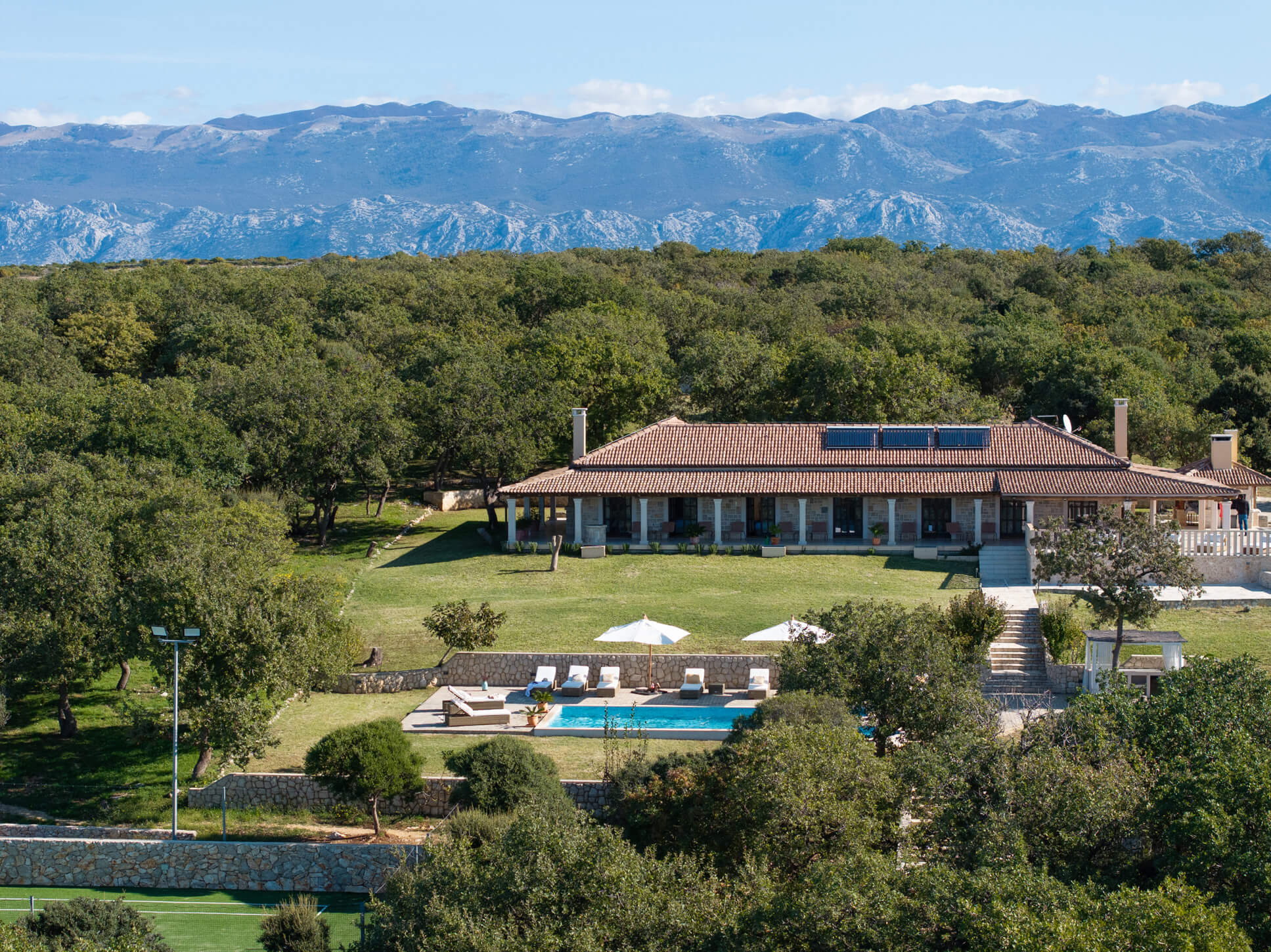 Aerial view of villa with private pool and tennis court