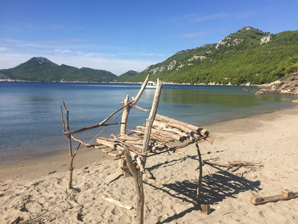 driftwood structure on sandy beach